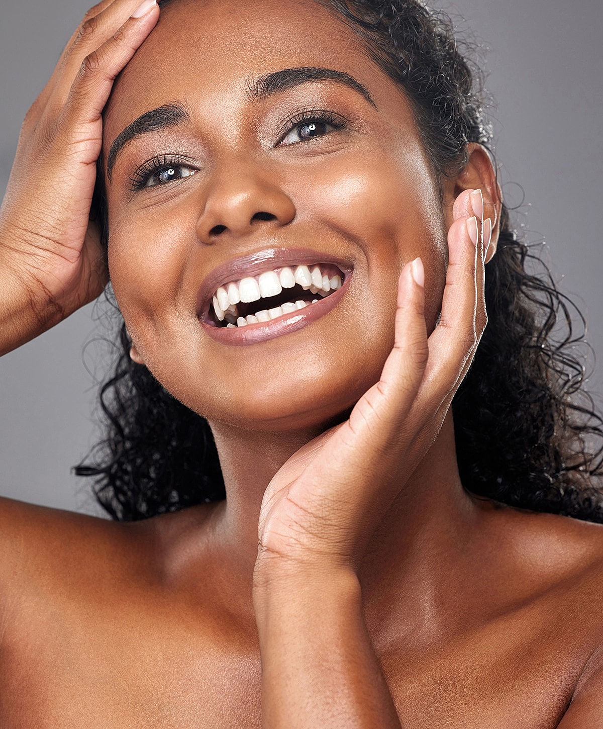 Smiling woman with curly hair and radiant skin