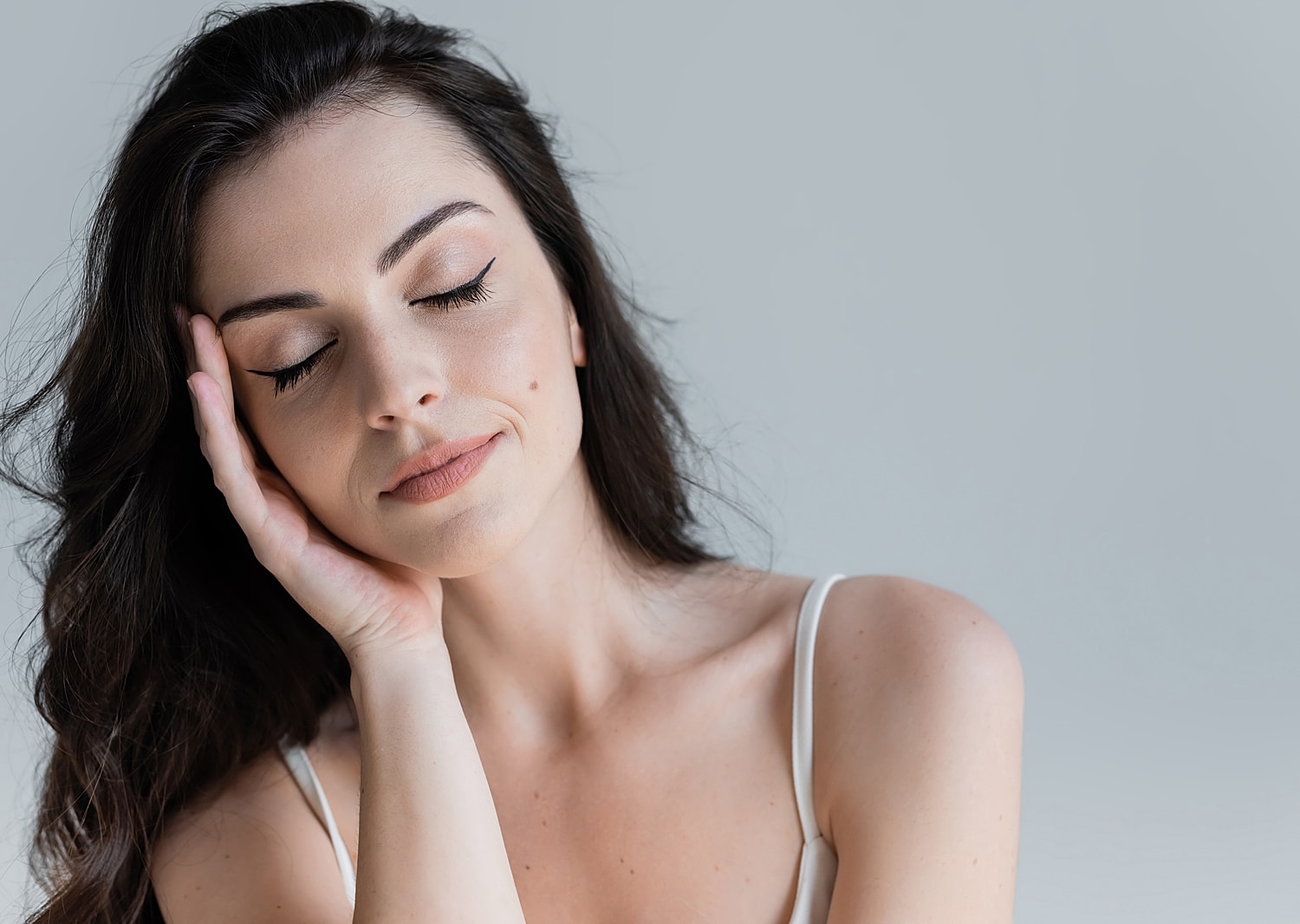 Woman resting her hand on her face.