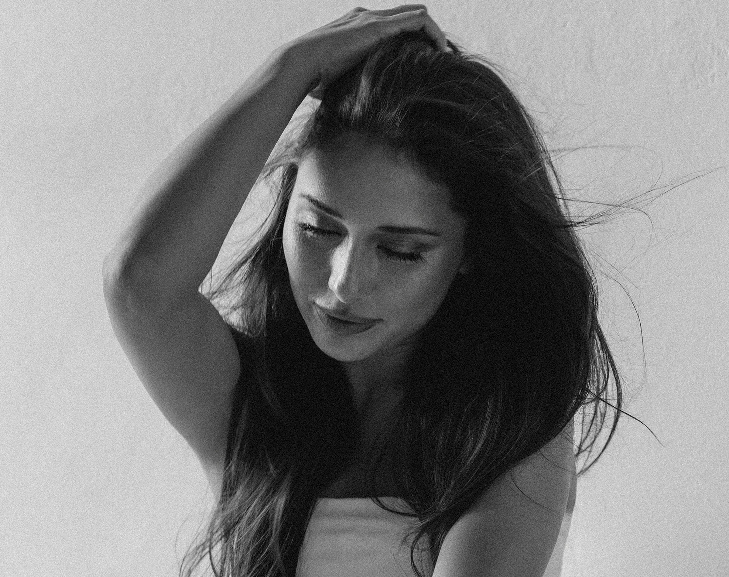 Woman in black and white portrait, thoughtful expression.